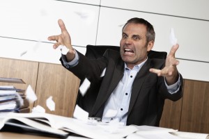 Frustrated office manager tearing document.